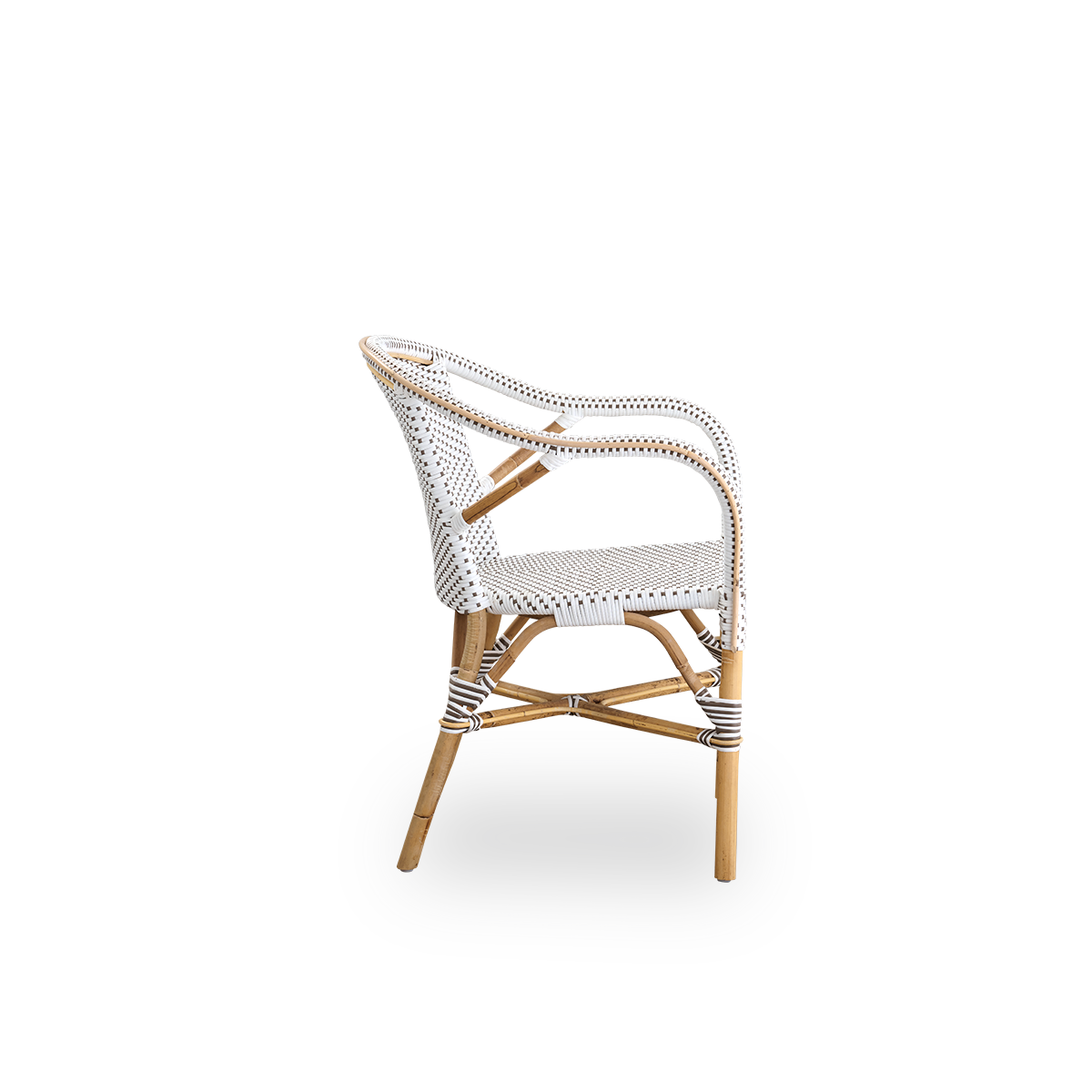 Seitenansicht des Madeleine Essstuhls mit Armlehnen. Rattanrahmen mit Sitz und Rückenlehne aus weißem ArtFibre mit braunen Punkten. Inspiriert vom Bistro-Design der 1950er Jahre.