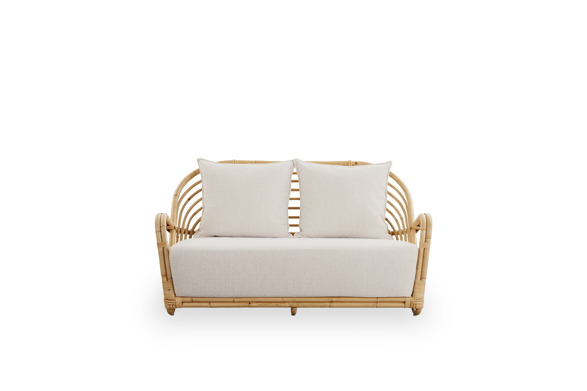 Vorderansicht des Charlottenborg 2-Sitzer-Sofas aus poliertem naturfarbenem Rattan, entworfen von Arne Jacobsen. Das Sofa verfügt über eine geschwungene Rückenlehne und Armlehnen, die in die Basis integriert sind, handgefertigt aus hochwertigem indonesisc