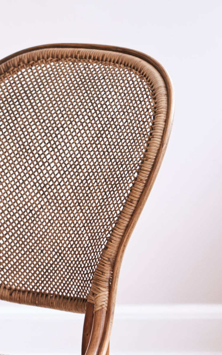 Dies ist ein Nahaufnahmebild von Rossini Dining Chair i antique rattan. Detailansicht der offenen Korbgeflecht-Rückenlehne und des Bistro-Gestells.