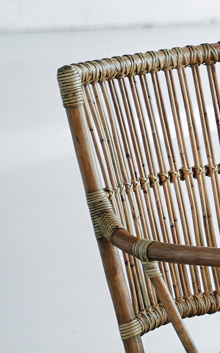 Dies ist ein Nahaufnahmebild von Piano Esszimmerstuhl in antique rattan. Detail der vertikalen Rattan-Sprossenrückenlehne und umwickelten Verbindungen.