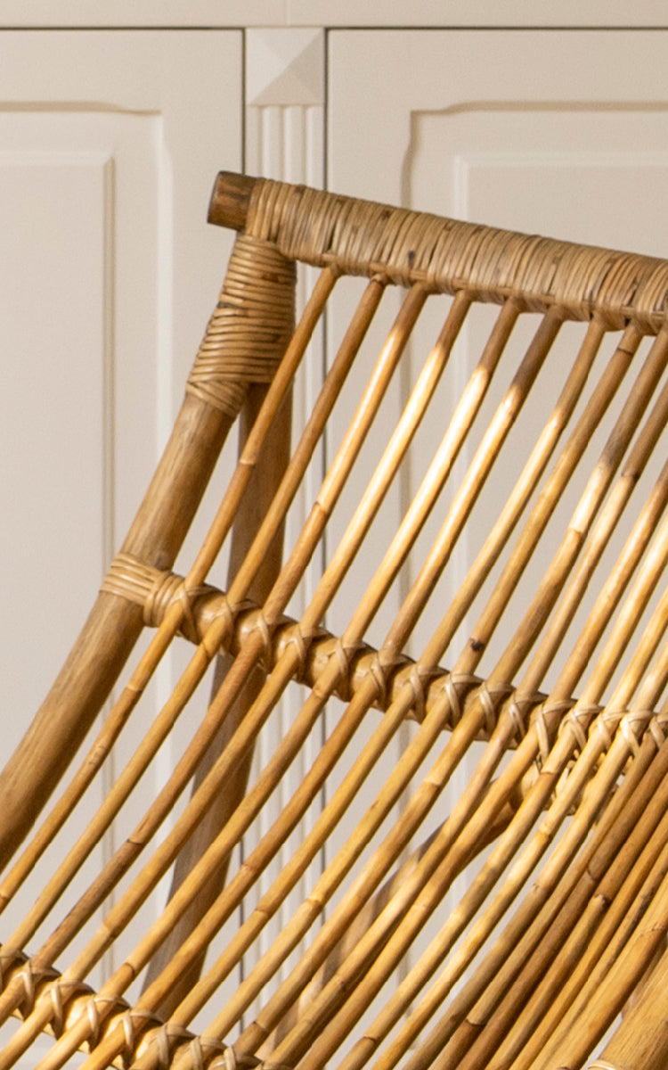 Dies ist ein Nahaufnahmebild von Michelangelo Daybed i antique rattan. Detail der geschwungenen skulpturalen Rattanstab-Konstruktion und umwickelten Verbindungen.