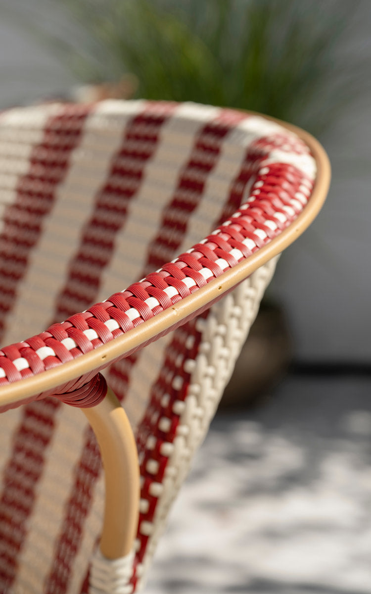 Dies ist ein Nahaufnahmebild von Madeleine Außen-Esszimmerstuhl in almond aluminum frame striped ivory burgundy. Gestreiftes Geflecht, burgunder Kante.
