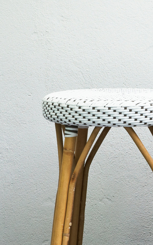 Dies ist ein Nahaufnahmebild von Simone Barstuhl in white w cappuccino dot ArtFibre Skin on Rattan frame. Vor einer weißen Wand gezeigt.