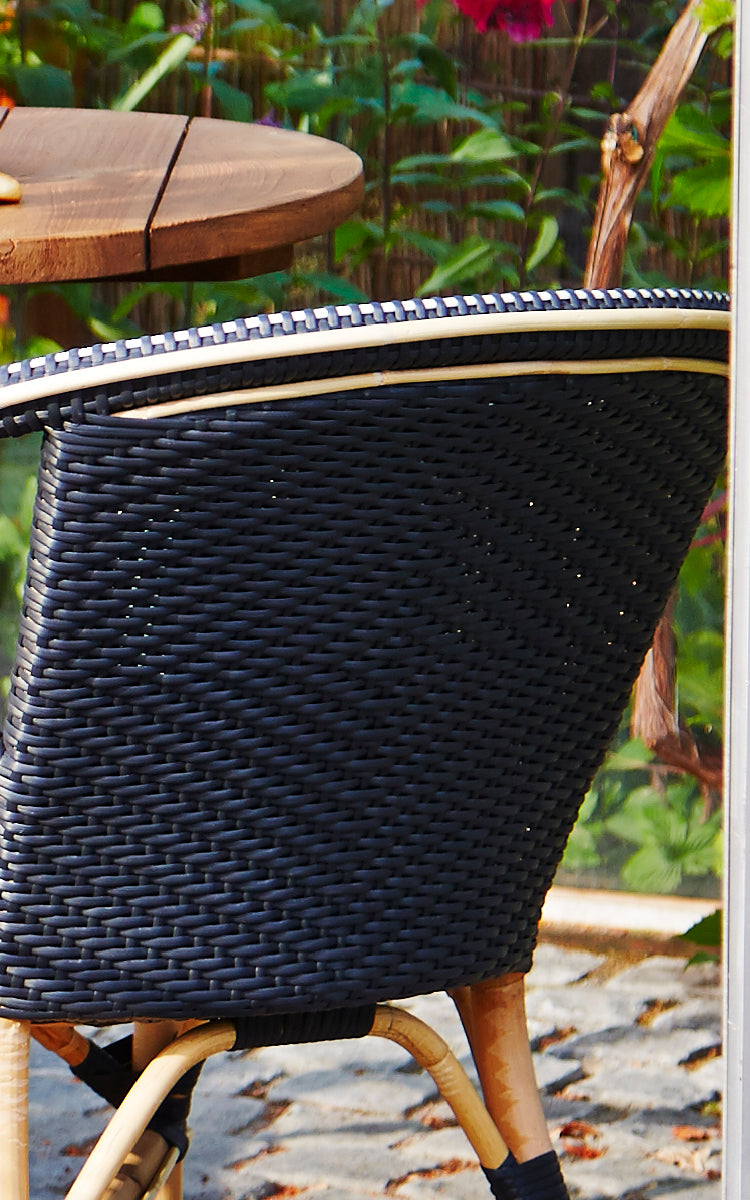 Dies ist ein Nahaufnahmebild von Madeleine Esszimmerstuhl in black ArtFibre skin on rattan frame. Dichtes schwarzes Geflecht mit Rattanrahmenkante.