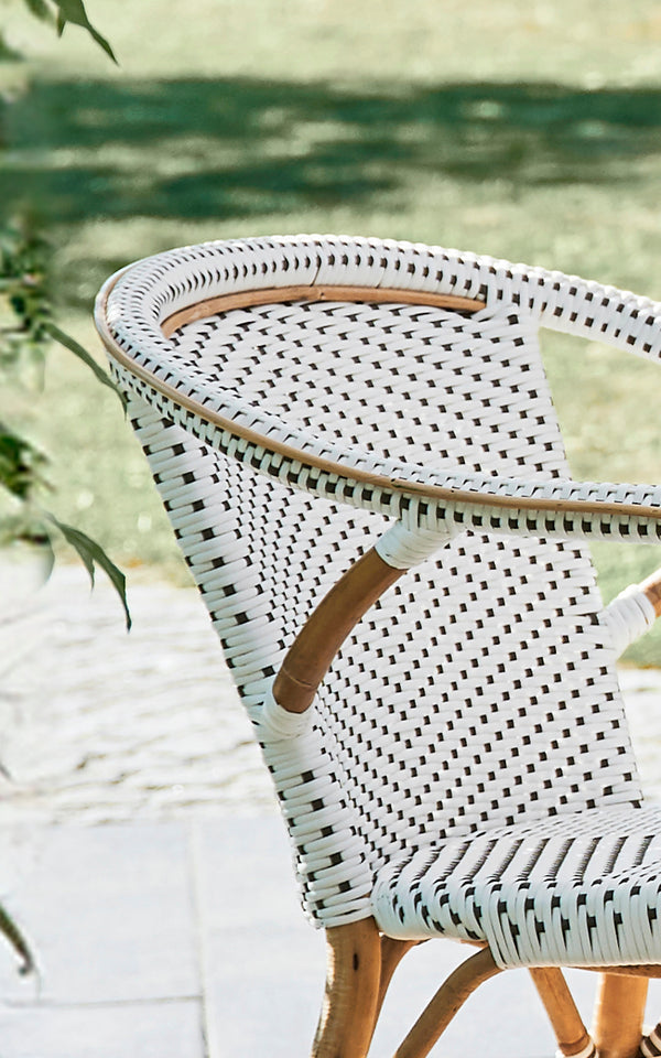Dies ist ein Nahaufnahmebild von Madeleine Esszimmerstuhl in white w cappuccino dot ArtFibre skin on rattan frame. Feines Punkt-Flechtmusterdetail.