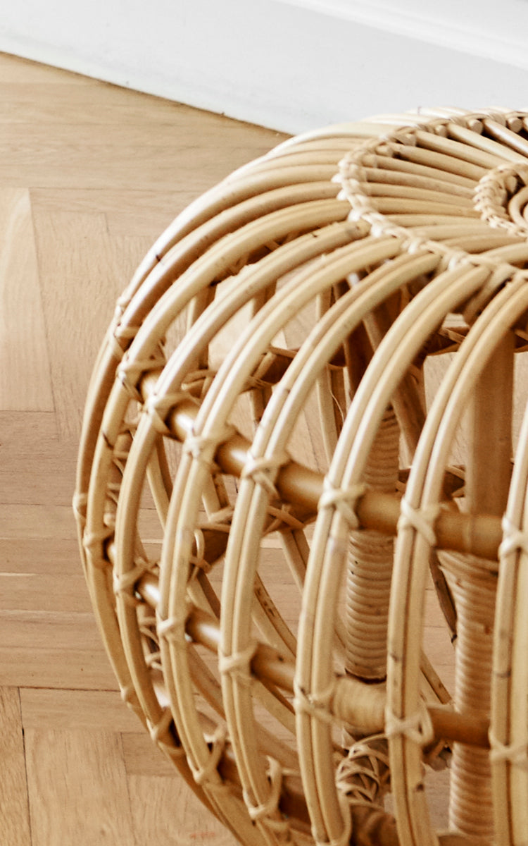 Dies ist ein Nahaufnahmebild von Ottoman Large in natural skin on rattan. Detail der großen naturfarbenen Rattan-Käfigstruktur auf Parkett.
