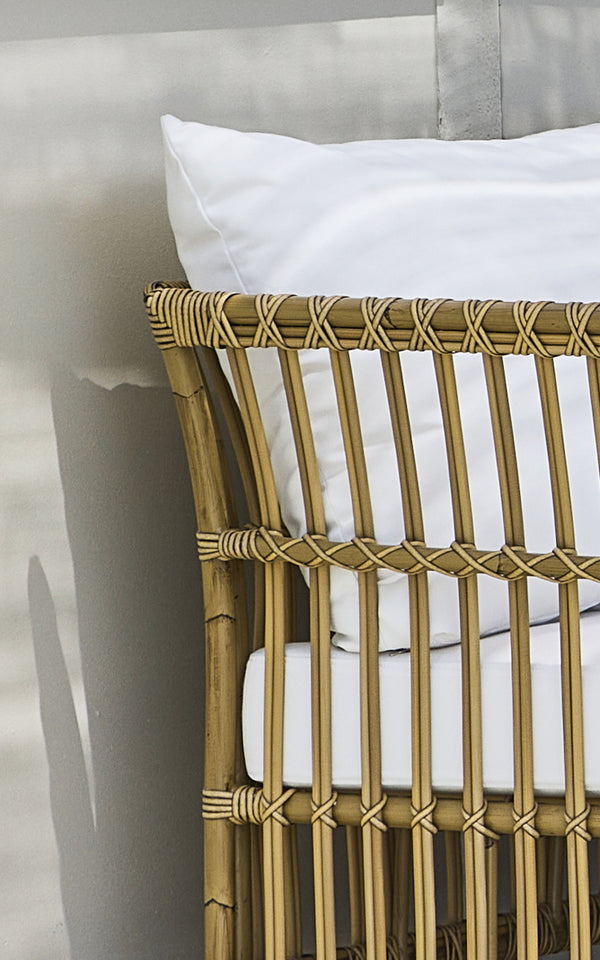 Dies ist ein Nahaufnahmebild von Maggie Sofa Eckmodul in antique aluminium artfibre. Vertikaler Lattenrahmen mit umwickelten Verbindungen und weißem Kissen.