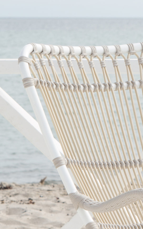Dies ist ein Nahaufnahmebild von Monet Exterior Rocking Chair i dove white aluminium artfibre. Detail der Schlaufenbogen-Rückenlehne.