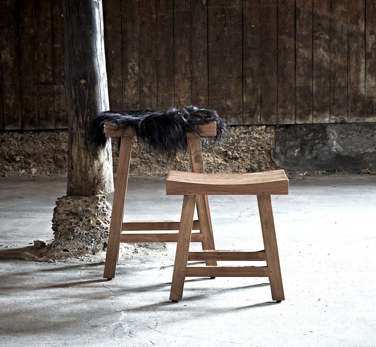 Dies ist ein Lifestyle-Bild von Charles Hocker in teak indoor, in einem hell-weißen Interieur mit Wandvertäfelung und Fischgrätparkett.