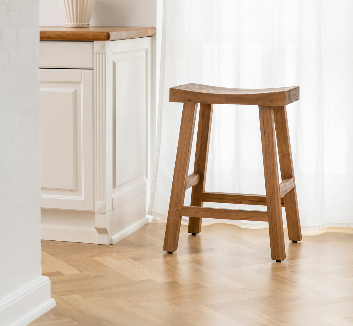 Dies ist ein Lifestyle-Bild von Charles Barstuhl in teak indoor, in einem hell-weißen Interieur mit Wandvertäfelung und Fischgrätparkett.
