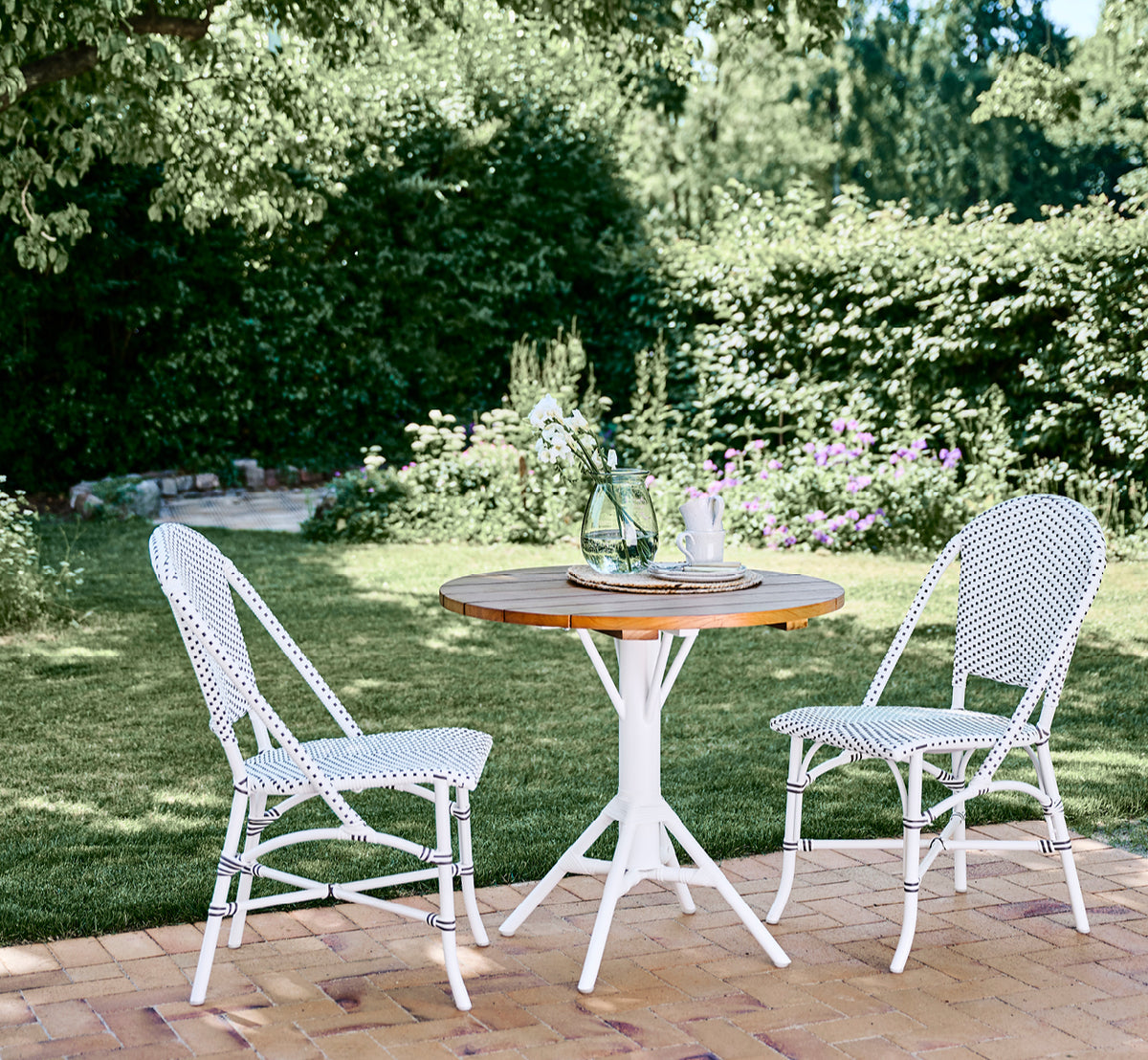 Dies ist ein Lifestyle-Bild von Sofie Außen-Esszimmerstuhl in white aluminium frame white w cappuccino dot artfibre.