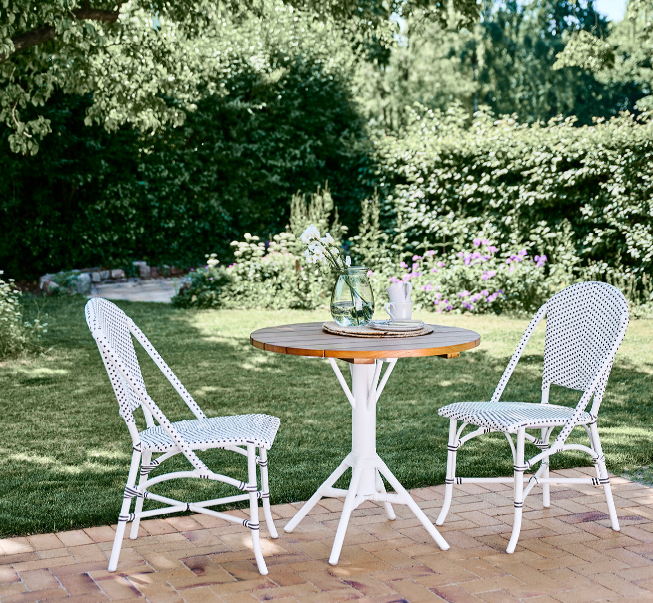 Dies ist ein Lifestyle-Bild von Sofie Außen-Esszimmerstuhl in white aluminium frame white w cappuccino dot artfibre.