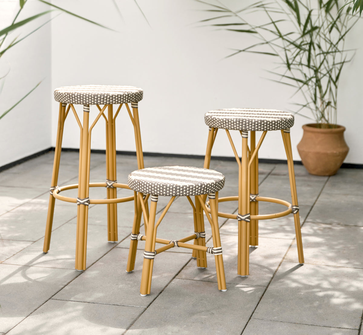 Dies ist ein Lifestyle-Bild von Simone Außen-Barstuhl in almond aluminium frame striped cappuccino ivory artfibre.