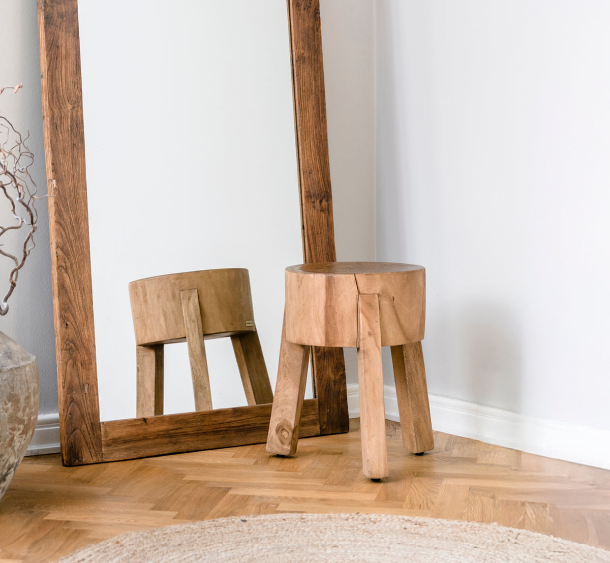 Dies ist ein Lifestyle-Bild von Roger Hocker in teak indoor. An einem Holzschreibtisch mit Lampe und Pflanze in einem hellen Fischgrät-Arbeitszimmer platziert.