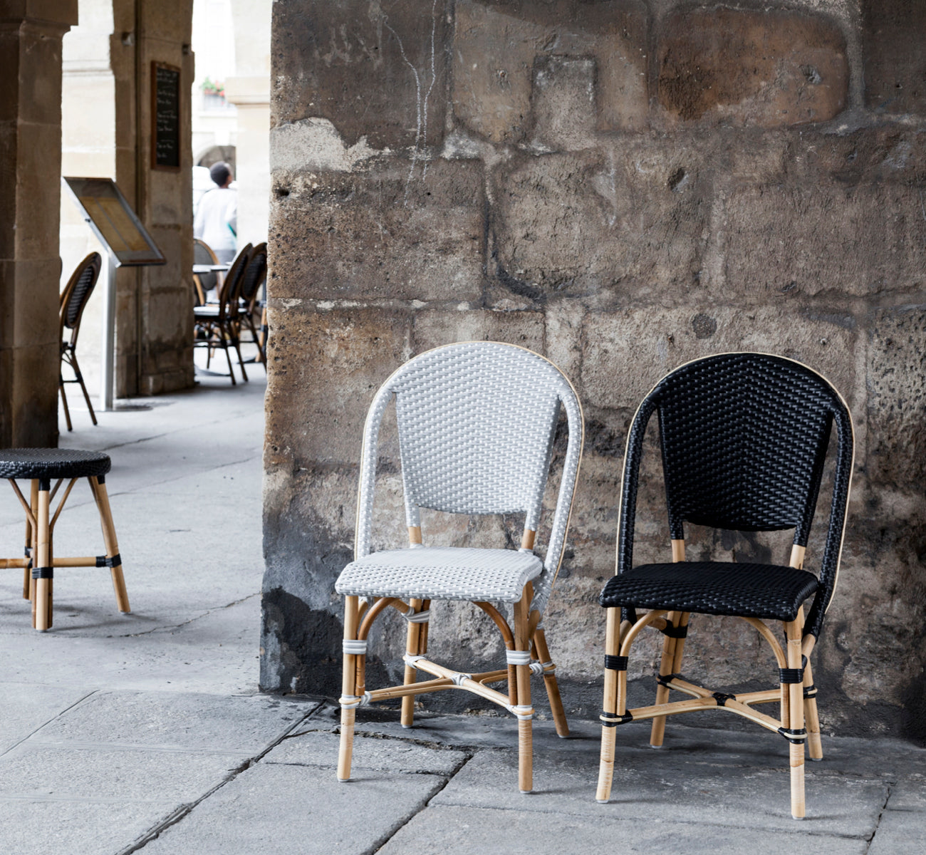 Dies ist ein Lifestyle-Bild von Sofie Esszimmerstuhl in black artfibre skin on rattan frame. In einem hellen Interieur gestylt.