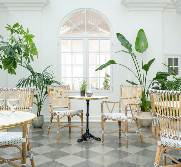 Dies ist ein Lifestyle-Bild von Monique Esszimmer-Armlehnstuhl in white w cappuccino dot artfibre skin on rattan frame. In einem hellen Interieur gestylt.