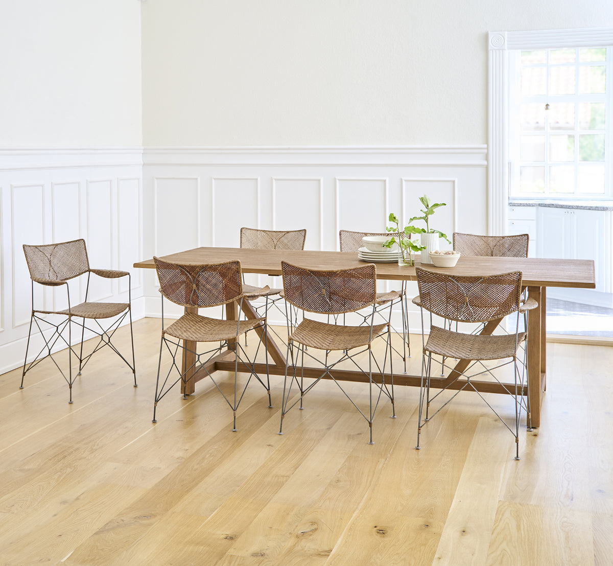 Dies ist ein Lifestyle-Bild von Lucas Teak Dining Table 240X100 cm in teak indoor. Mit modernen Stühlen in einem hellen Raum mit weißen Wandpaneelen kombiniert.