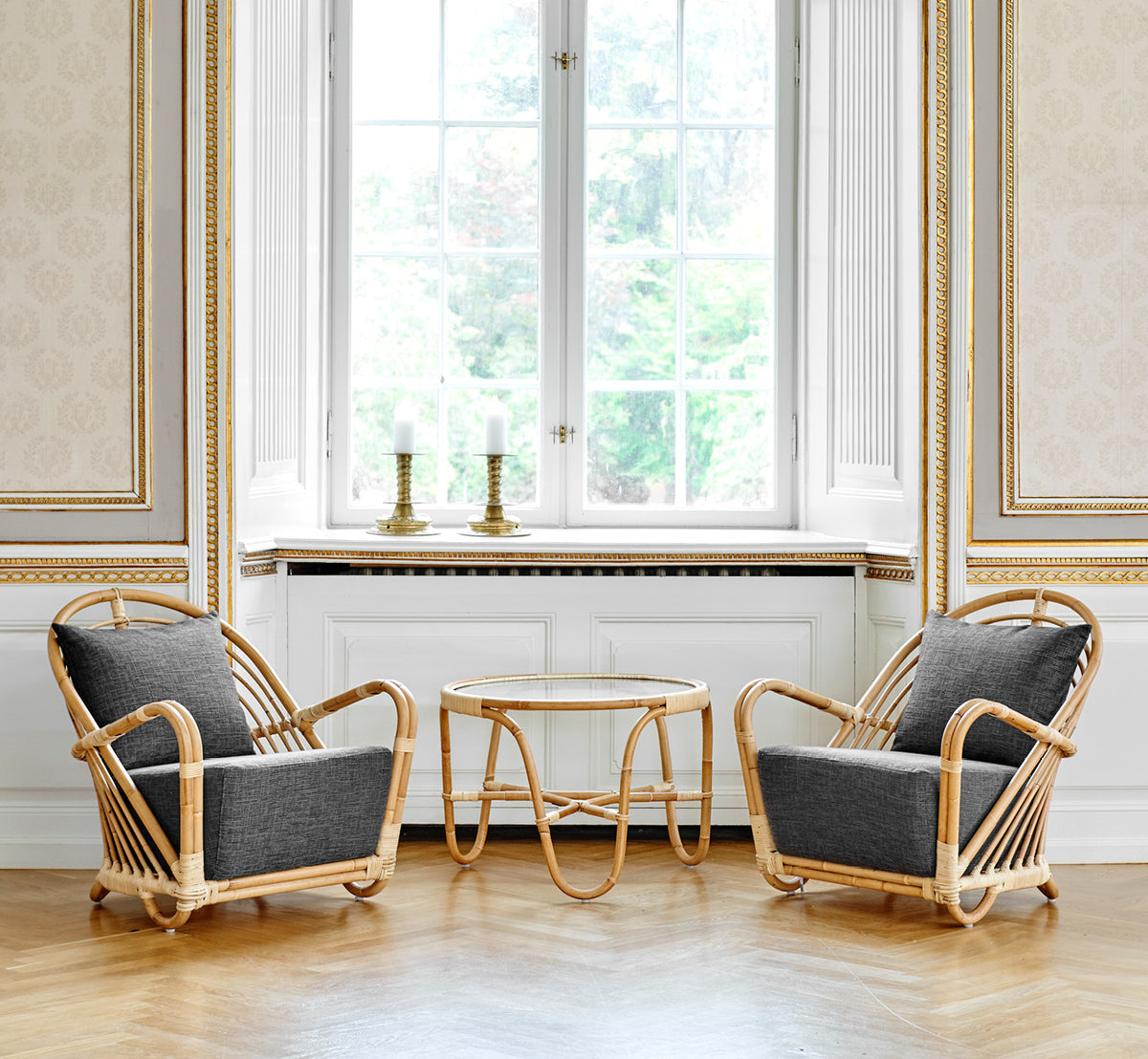 Dies ist ein Lifestyle-Bild von Charlottenborg Lounge-Sessel in polished Natural Rattan, in einem eleganten klassischen Interieur mit aufwändigen.