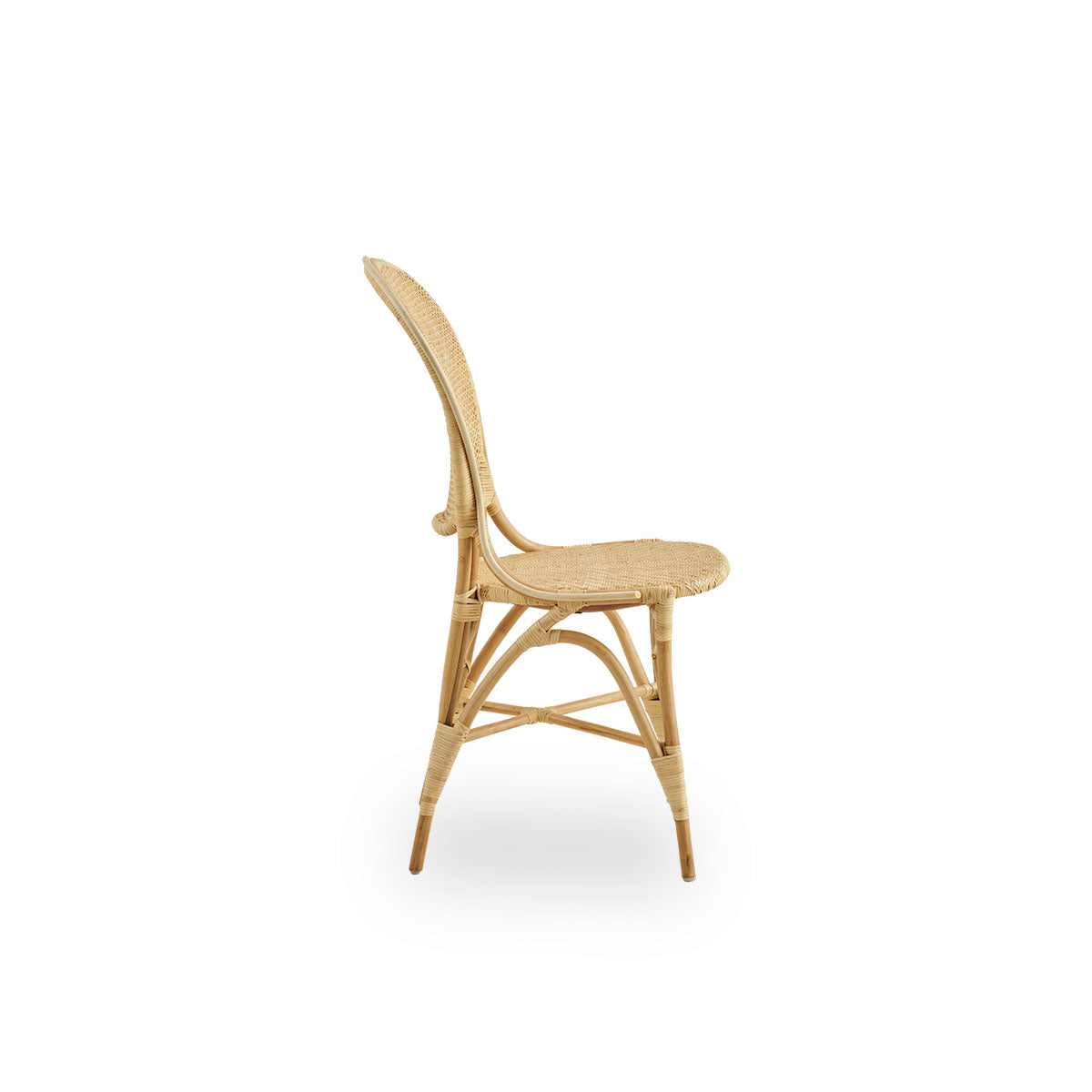 Plain side view of Rossini dining chair in natural rattan. Elegant wicker chair with round backrest in simple design. Handcrafted from high quality rattan.
