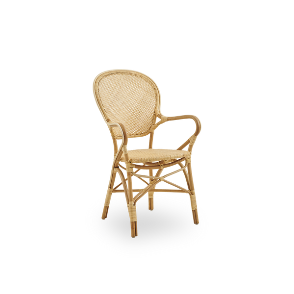 Seitenansicht des Rossini Essstuhls mit Armlehnen aus natürlichem Rattan. Eleganter Korbstuhl mit runder Rückenlehne und Armlehnen in schlichtem Design. Handgefertigt aus hochwertigem Rattan.