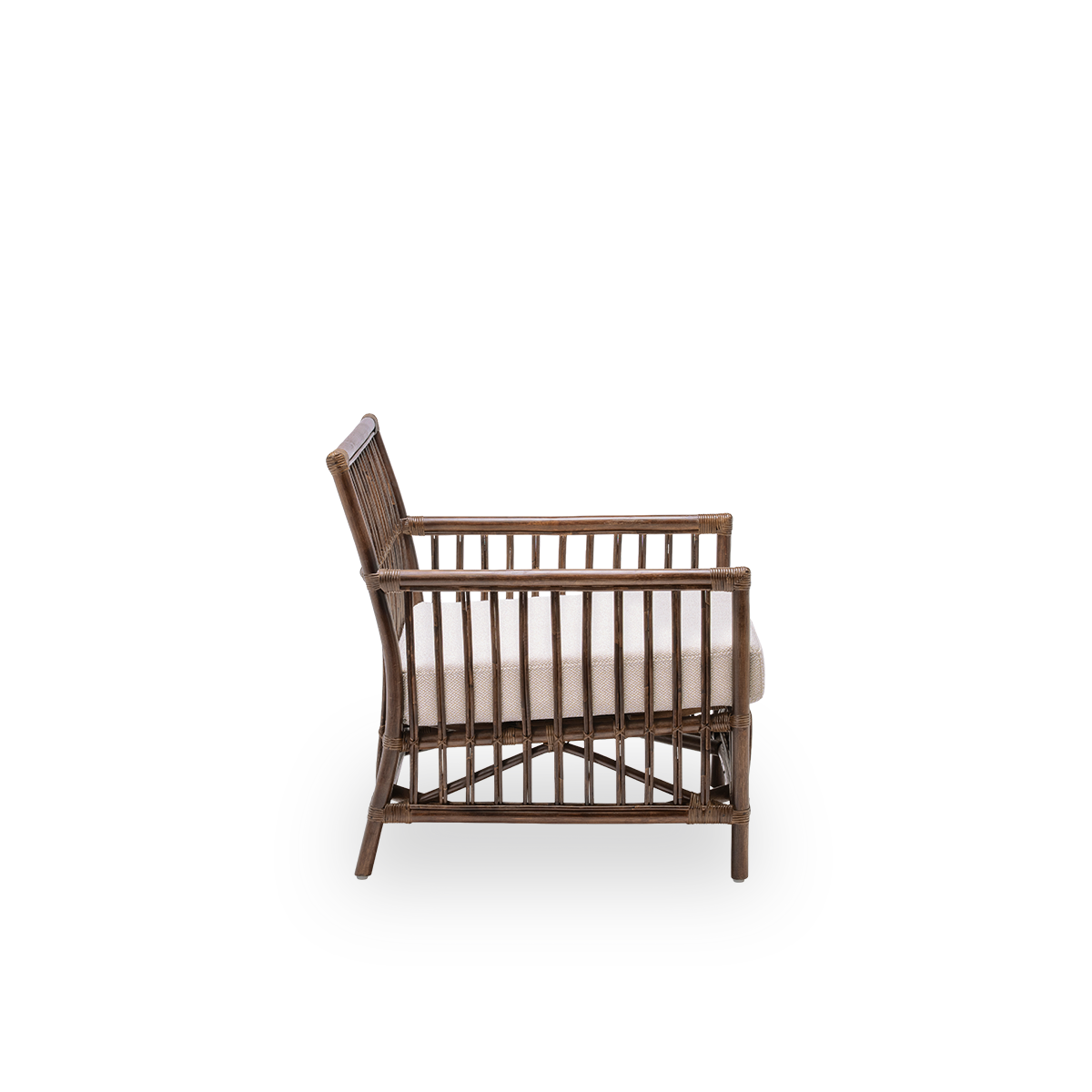 Einfache Seitenansicht des Caroline Loungesessels mit Sitzkissen, aus braunem Rattan. Ein schlichtes, elegantes dänisches Design, dessen detaillierte Flechtarbeit es zu einem ruhigen Element im Raum macht.