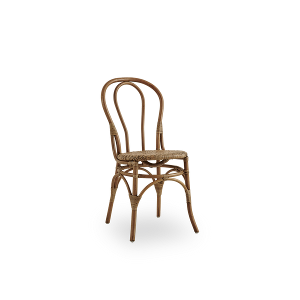 Seitenansicht des Lulu Essstuhls in Antique-Braun, handgefertigt aus hochwertigem indonesischem Rattan. Leichtes, elegantes Design mit rundem, schlichtem Rückenlehne.