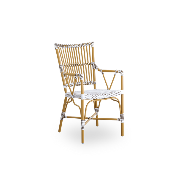Seitenansicht des Monique Outdoor-Essstuhls mit Armlehnen. Aluminiumrahmen in Mandel-Farbe mit Sitz aus weißem ArtFibre mit braunen Punkten geflochten. Inspiriert vom Bistro-Design der 1950er Jahre.

