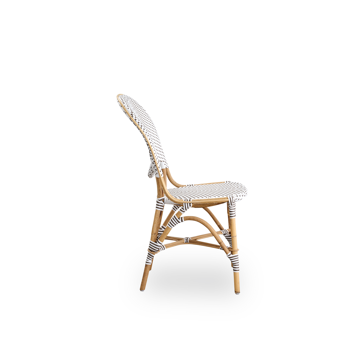 Seitenansicht des Isabell Essstuhls. Rattanrahmen mit Sitz und Rückenlehne aus weißem ArtFibre mit braunen Punkten. Inspiriert vom Bistro-Design der 1950er Jahre.