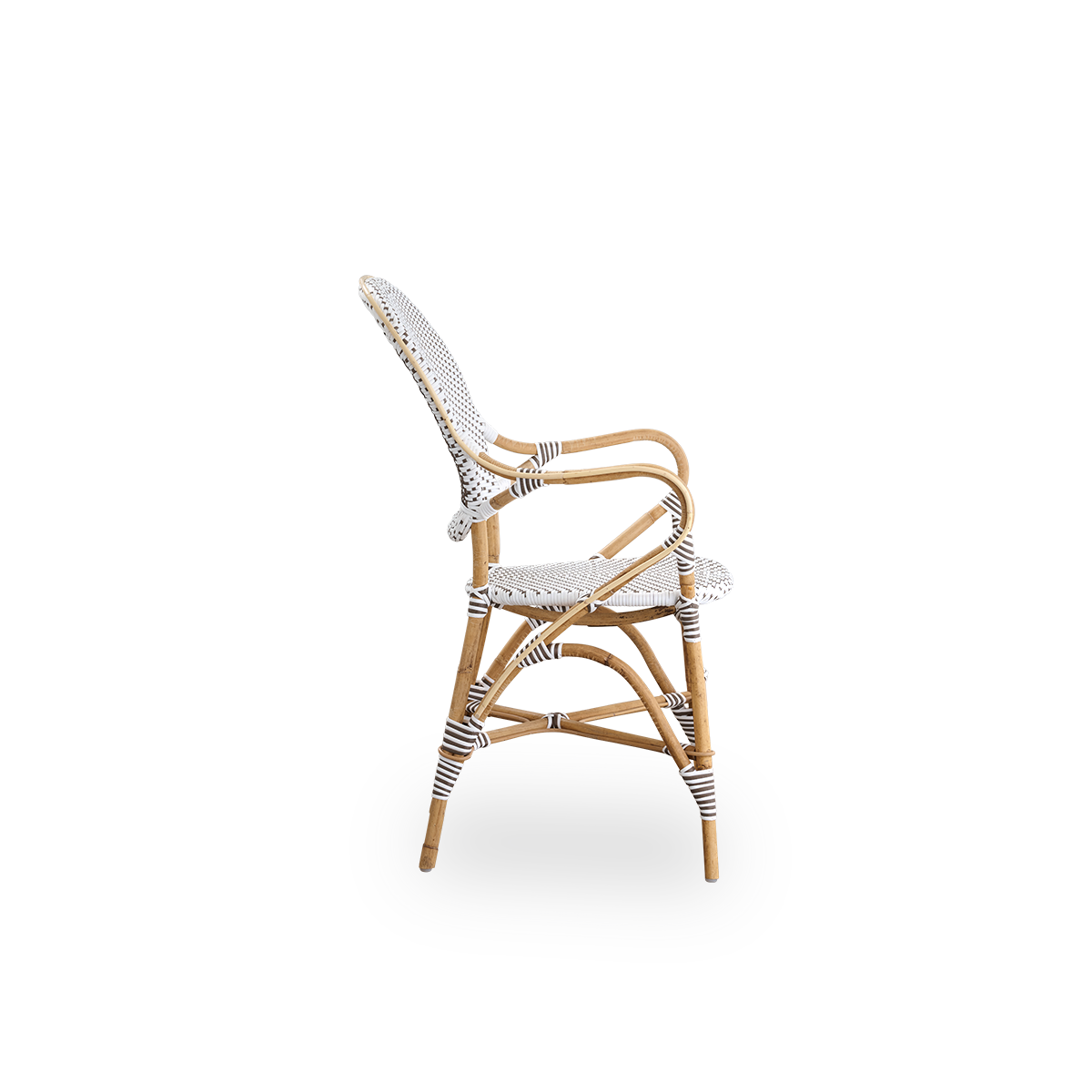 Seitenansicht des Isabell Essstuhls mit Armlehnen. Rattanrahmen mit Sitz und Rückenlehne aus weißem ArtFibre mit braunen Punkten. Inspiriert vom Bistro-Design der 1950er Jahre.