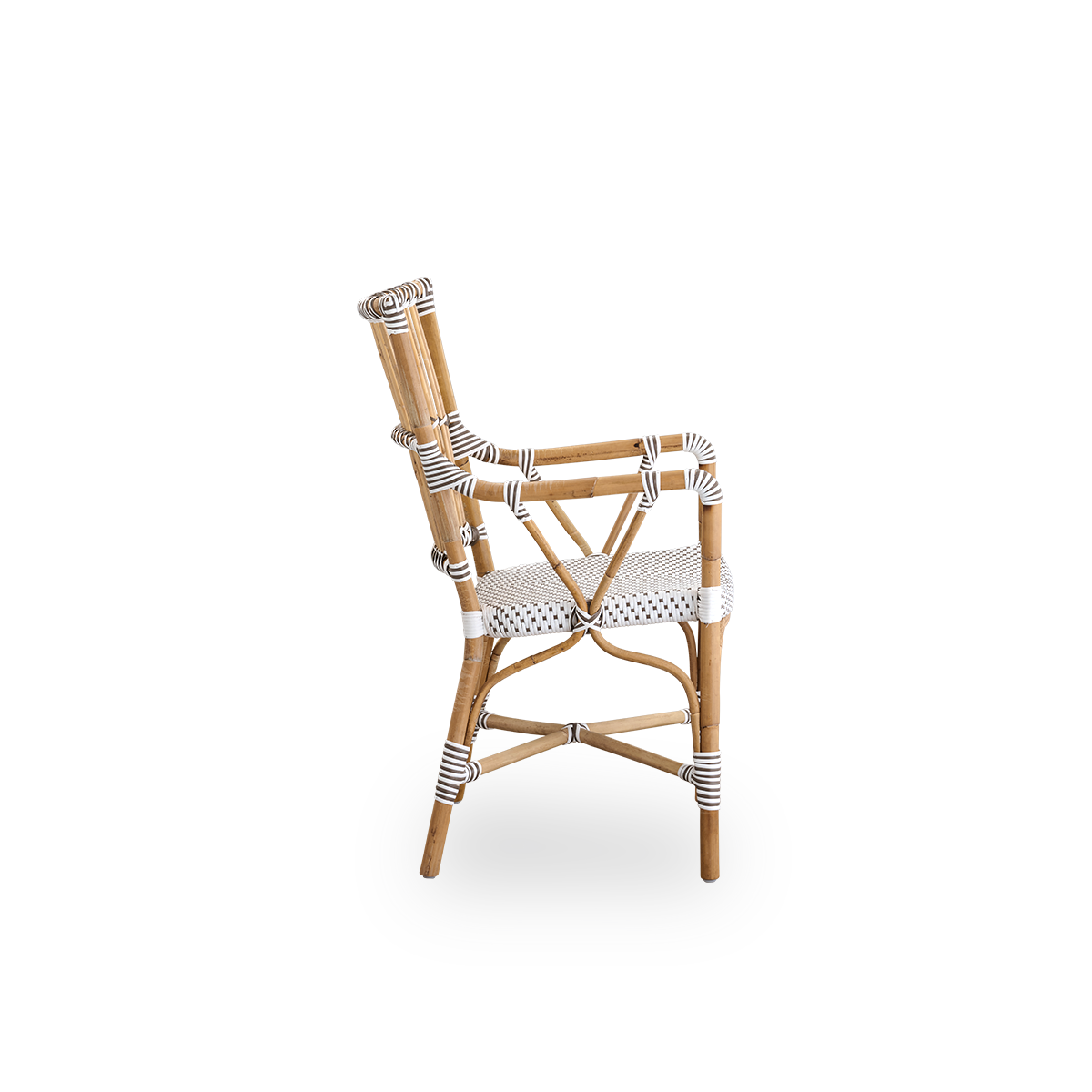 Seitenansicht des Monique Essstuhls mit Armlehnen. Rattanrahmen mit Sitzfläche aus ArtFibre in Weiß mit braunen Punkten. Inspiriert vom Bistro-Design der 1950er Jahre.