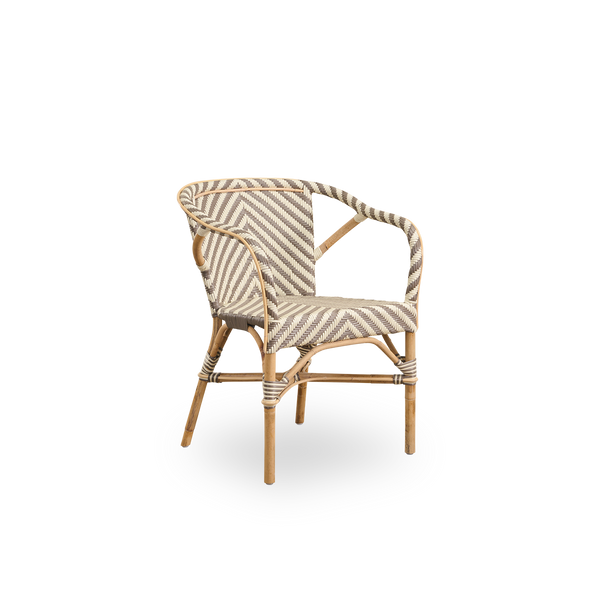 Seitenansicht des Madeleine Essstuhls mit Armlehnen. Rattanrahmen mit Sitz und Rückenlehne aus ArtFibre im elfenbein- und braunen Fischgrätmuster geflochten. Inspiriert vom Bistro-Design der 1950er Jahre.