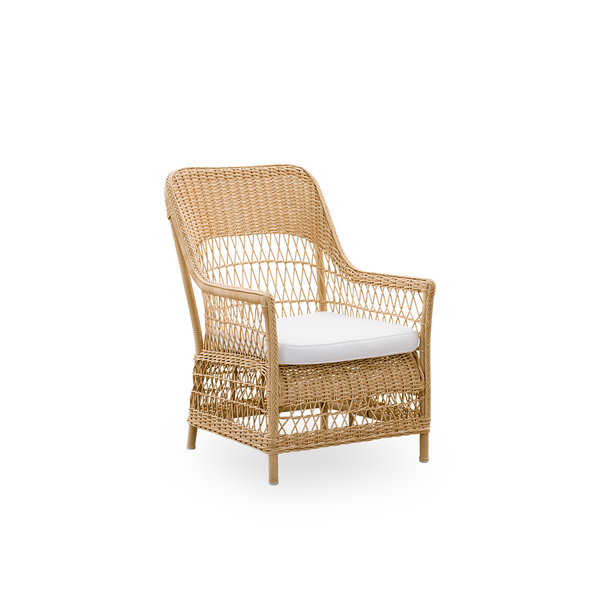 Seitenansicht des Dawn Outdoor-Loungestuhls in Naturfarbe, inspiriert vom britischen Kolonialstil. Romantischer Loungesessel mit Armlehne und hoher Rückenlehne. Vollständig geflochten aus ArtFibre auf handgebogenem Aluminiumrahmen.