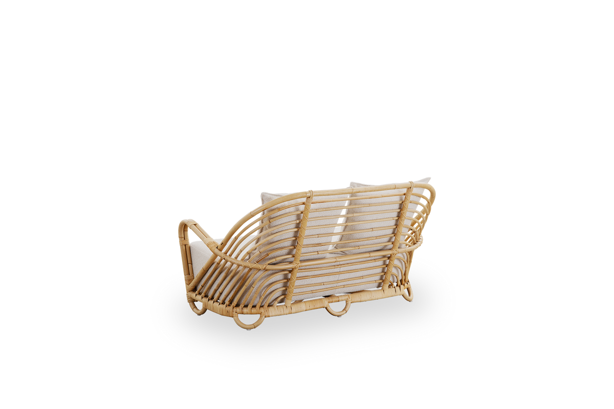 Rückseiten-Seitenansicht des Charlottenborg 2-Sitzer Sofas aus poliertem Natur-Rattan, entworfen von Arne Jacobsen. Das Sofa verfügt über eine geschwungene Rückenlehne und integrierte Armlehnen, handgefertigt aus hochwertigem indonesischem Rattan.