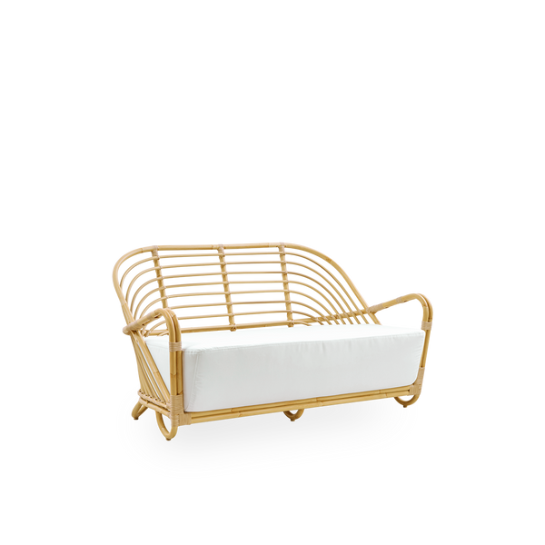 Seitenansicht des Charlottenborg 2-Sitzer-Outdoor-Sofas im Rattan-Look, entworfen von Arne Jacobsen. Das Sofa verfügt über eine gebogene Rückenlehne und in die Basis integrierte Armlehnen, handgefertigt mit Alu-Rattan-Rahmen und gewebten ArtFibre-Details.