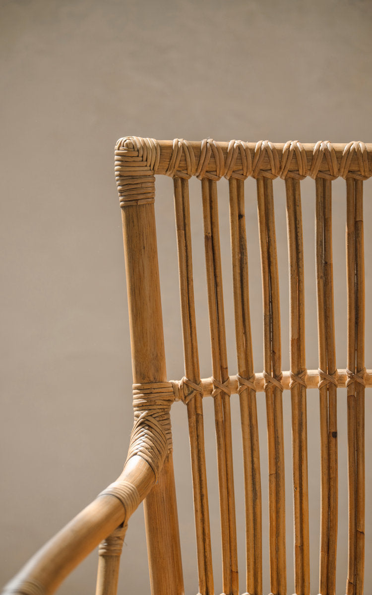Dies ist ein Nahaufnahmebild von Piano Esszimmerstuhl in antique rattan. Rückenlehne mit Streben und handumwickelten Rattanverbindungen.