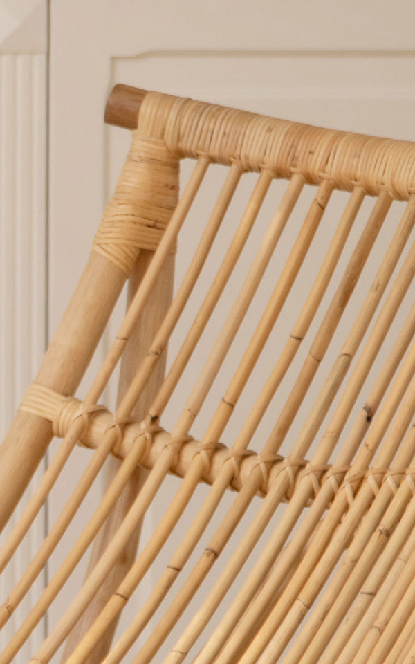Dies ist ein Nahaufnahmebild von Michelangelo Daybed i natural rattan. Detail der glatten gebogenen Rattanstäbe und der geflochtenen Bindung an den Verbindungen.