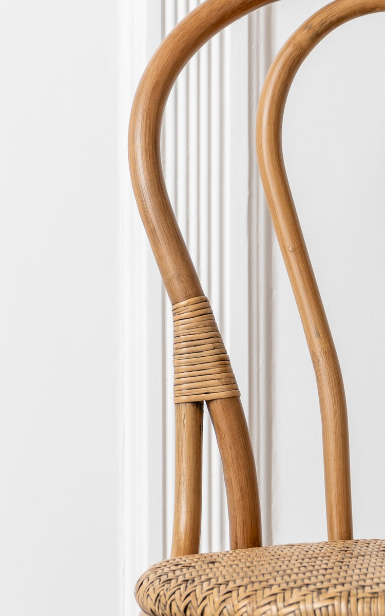 Dies ist ein Nahaufnahmebild von Lulu Esszimmerstuhl in antique rattan. Der gebogene Bugholzrahmen mit Rattanumwicklung und gewebtem Sitz betonen das Design.