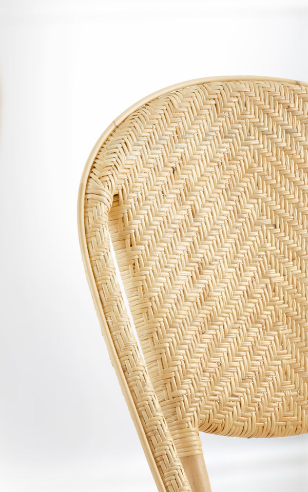 Dies ist ein Nahaufnahmebild von Alanis Esszimmerstuhl in natural rattan.