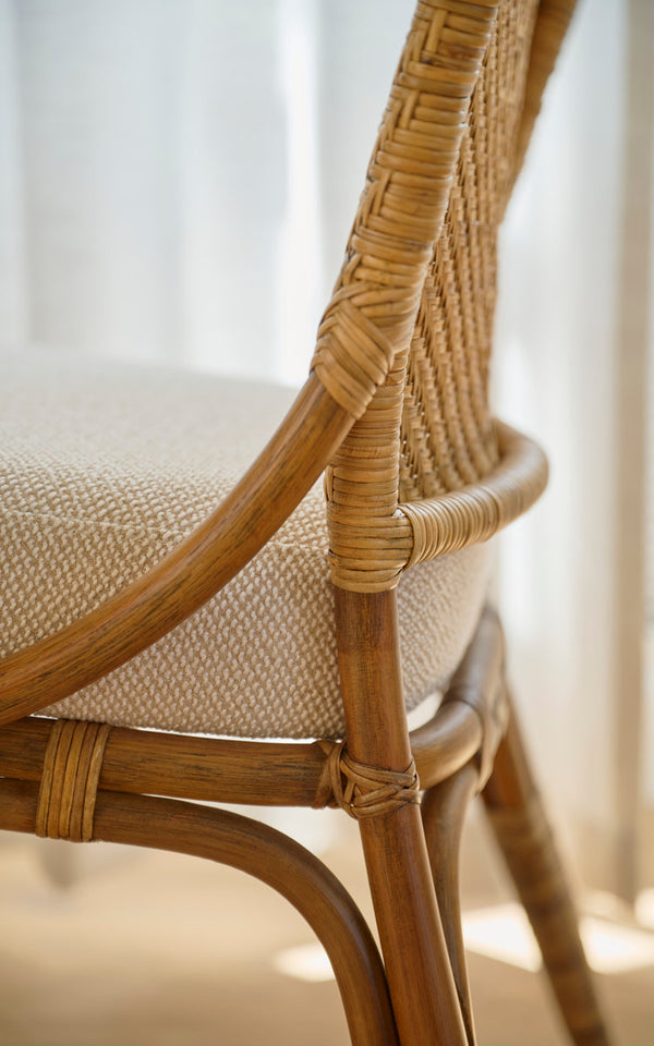 Dies ist ein Nahaufnahmebild von Melody Esszimmerstuhl in antique rattan. Rückenlehne aus Geflecht, gepolsterter Sitz und umwickelte Verbindungen.
