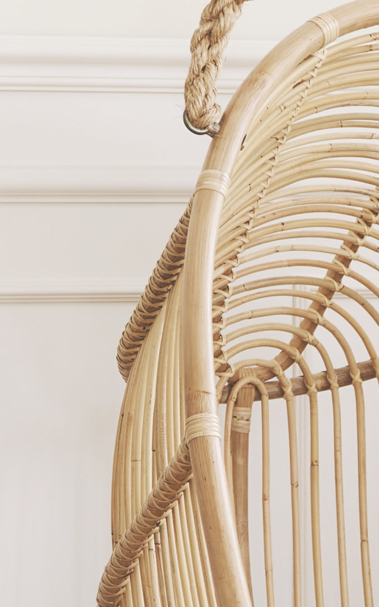 Dies ist ein Nahaufnahmebild von Renoir Hängesessel in natural rattan. Detail des naturfarbenen Rattanrahmens mit radialen Speichen und Seilaufhängung.