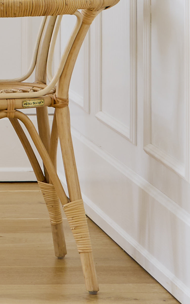 Dies ist ein Nahaufnahmebild von Tony Side Table i natural rattan. Detail der Glasplattenkante und der umwickelten Rattanrahmen-Konstruktion.