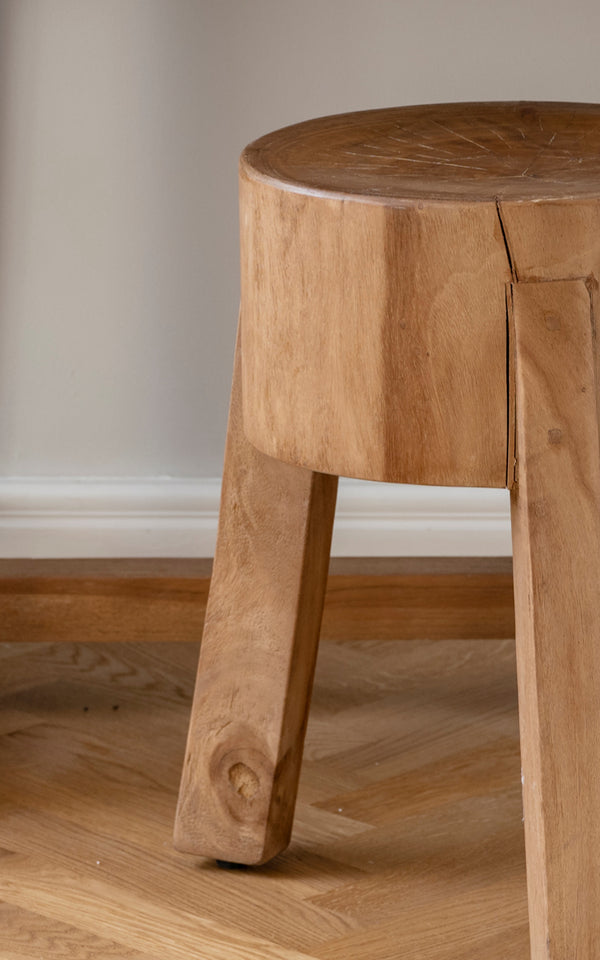 Dies ist ein Nahaufnahmebild von Roger Hocker in teak indoor. Detail des massiven Teaksitzes und der drei kräftigen schrägen Beine.