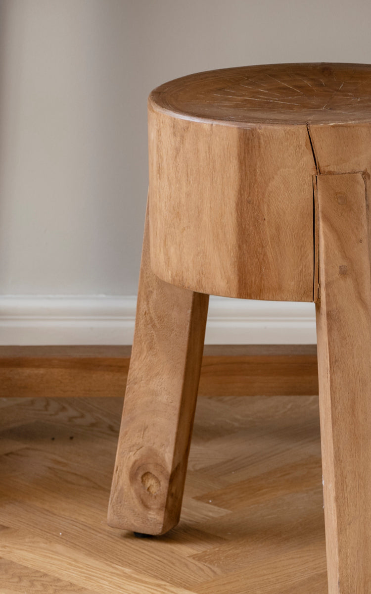 Dies ist ein Nahaufnahmebild von Roger Hocker in teak indoor. Detail des massiven Teaksitzes und der drei kräftigen schrägen Beine.