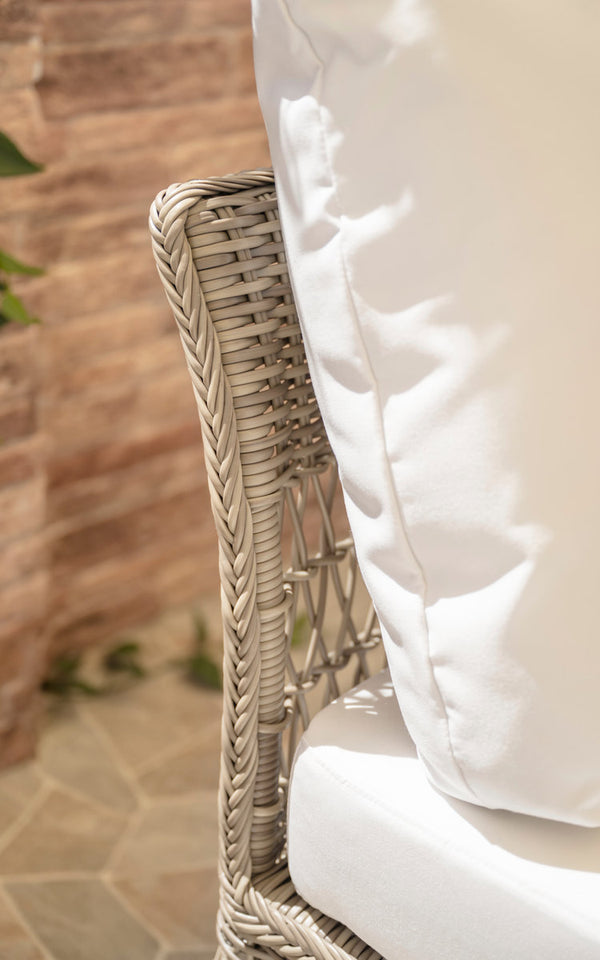 Dies ist ein Nahaufnahmebild von Mona Außen-Modulsofa-Corner Module in antique grey artfibre aluminium. Geflochtene Armlehne mit weißem Kissen.
