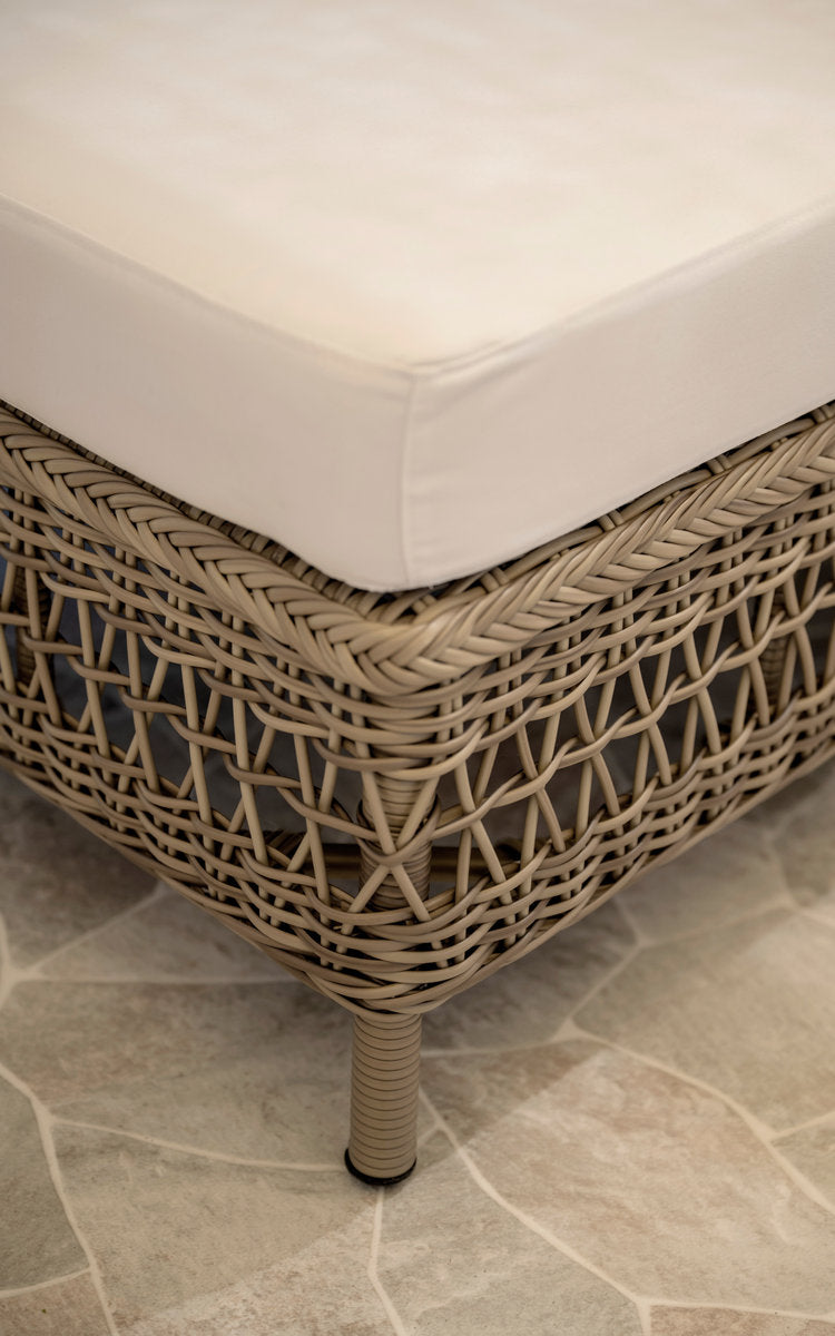 Dies ist ein Nahaufnahmebild von Mona Außen-Modulsofa-Pouf Module in antique grey artfibre aluminium. Geflochtene Poufkante mit weißem Kissen.