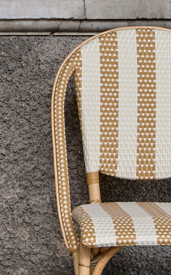 Dies ist ein Nahaufnahmebild von Sofie Esszimmerstuhl in striped honey ivory artfibre skin on rattan frame.