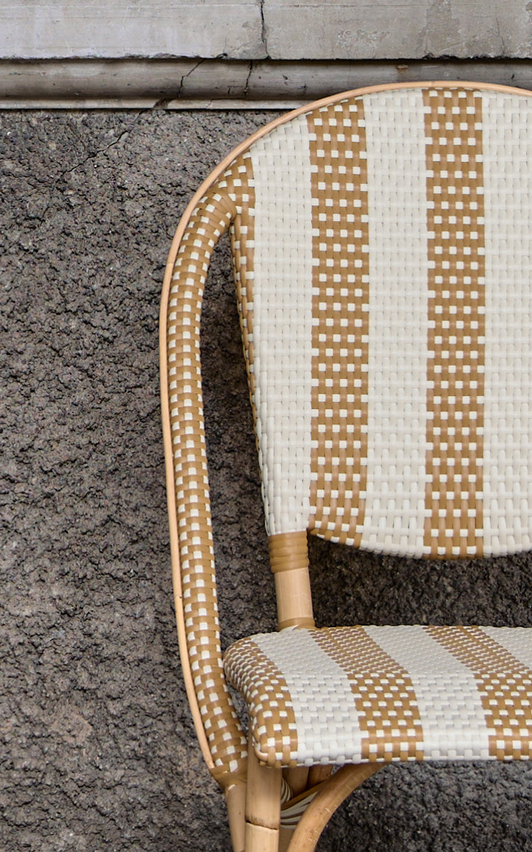 Dies ist ein Nahaufnahmebild von Sofie Esszimmerstuhl in striped honey ivory artfibre skin on rattan frame.