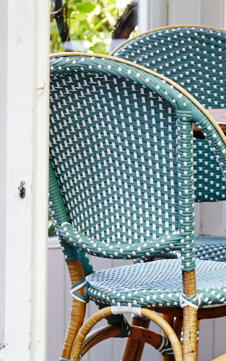 Dies ist ein Nahaufnahmebild von Sofie Esszimmerstuhl in salvie green w white dot artfibre skin on rattan frame.