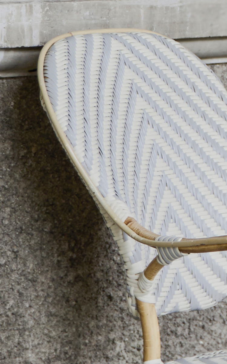 Dies ist ein Nahaufnahmebild von Isabell Esszimmer-Armlehnstuhl in chevron Grey Ivory ArtFibre Skin on Rattan frame.
