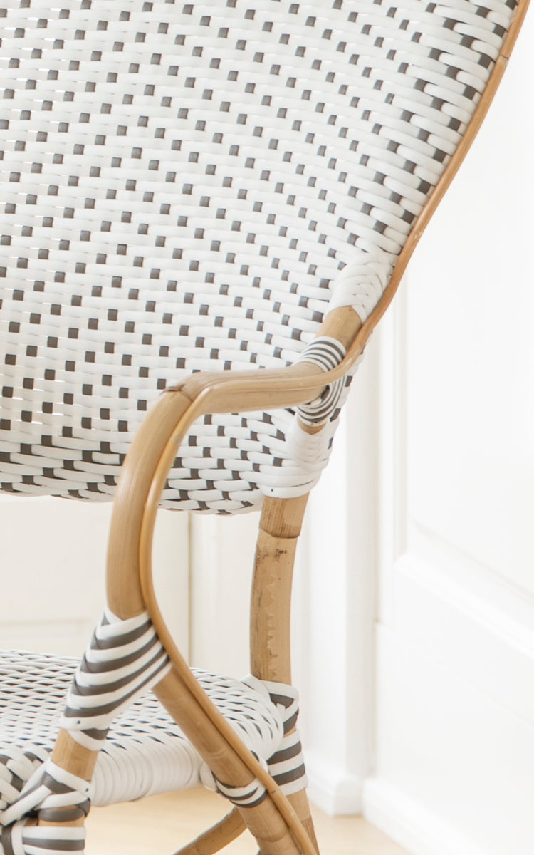 Dies ist ein Nahaufnahmebild von Isabell Esszimmer-Armlehnstuhl in white w cappuccino dot ArtFibre Skin on Rattan frame.